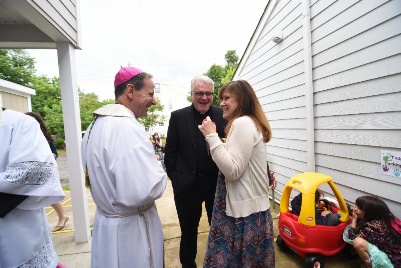 Kathleen Wilson shows Bishop Burbidge and Father Rooney the outdoor play area. (May 6, 2017)