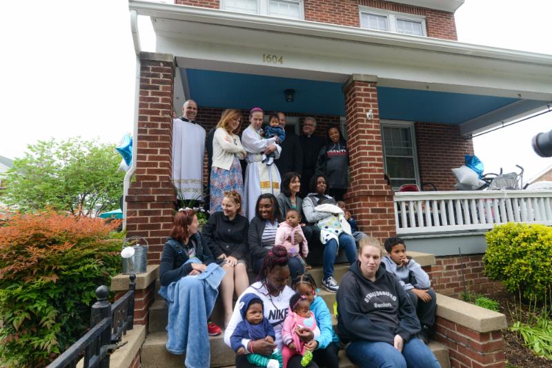 Bishop Burbidge poses for a picture with our residents on the porch of one of our new homes. (May 6, 2017)